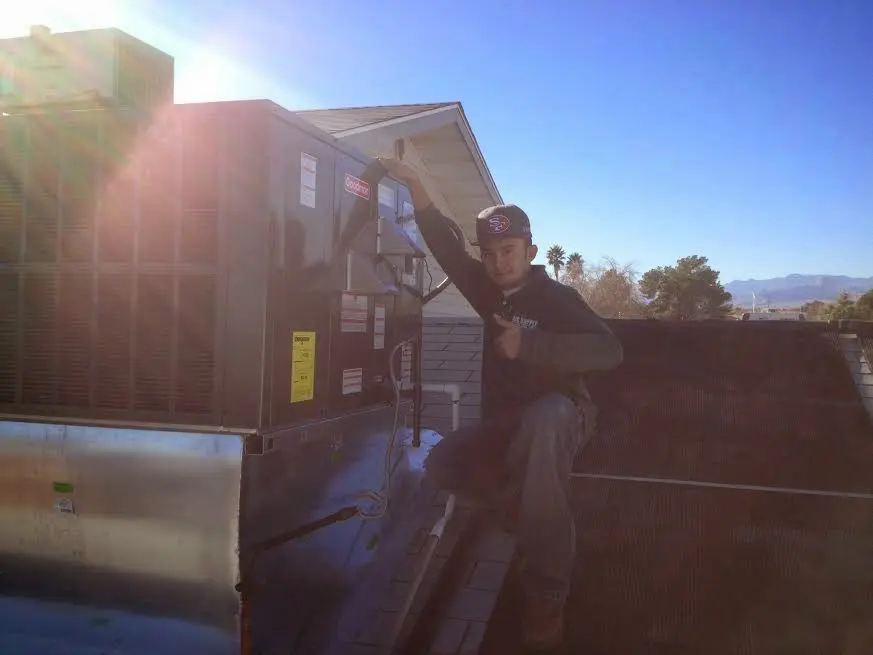 HVAC technician performing Air Duct Repair on a rooftop unit in Steger